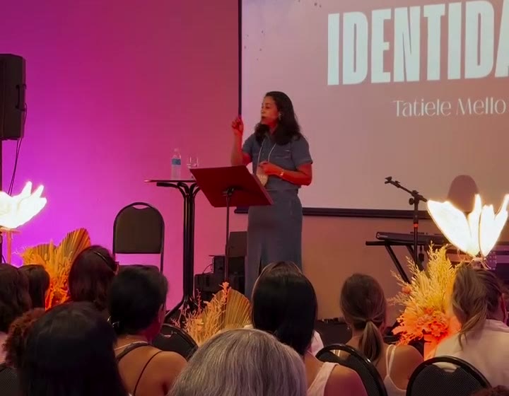 Tatiele Mello em uma palestra, de frente para a plateia